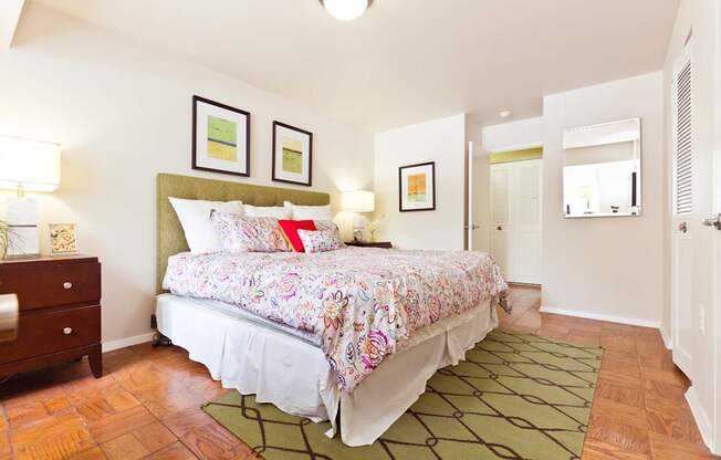 A bedroom with a floral bedspread and a green headboard.