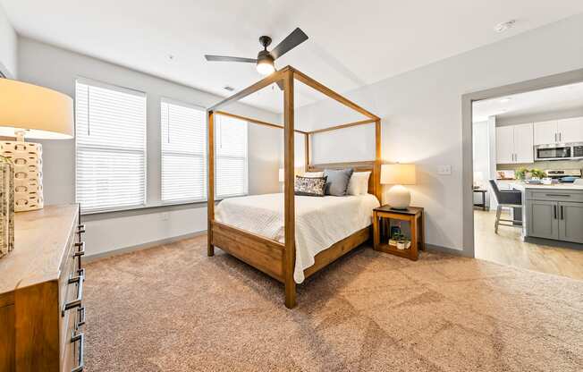 A bedroom with a four poster bed and a ceiling fan