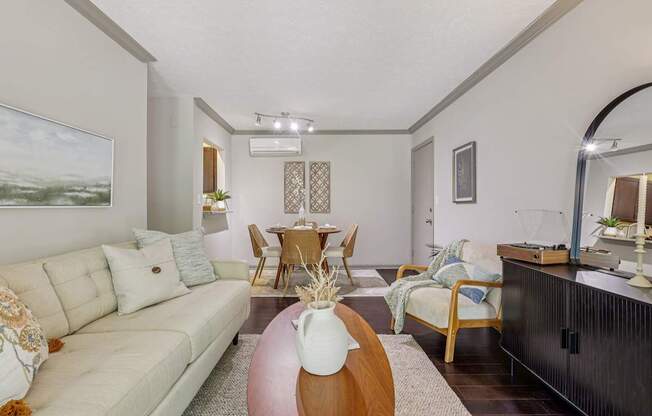 A living room with a white couch and a wooden coffee table.