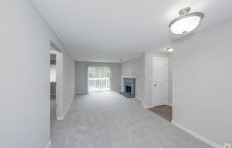 A spacious living room with a fireplace and sliding glass doors.