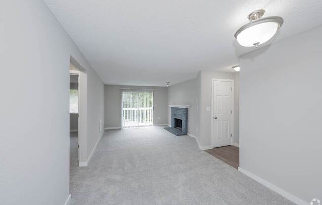A spacious living room with a fireplace and sliding glass doors.