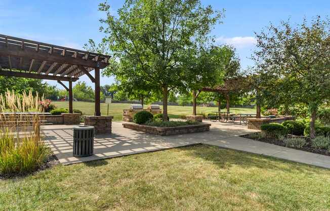 A park with a pavilion, benches, and trees.