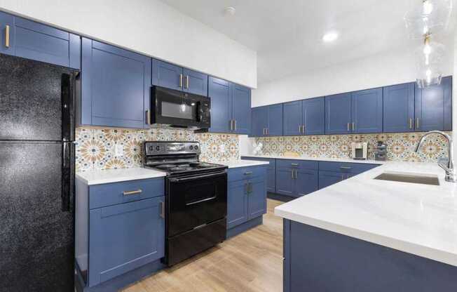 a kitchen with blue cabinets and a stove and a microwave