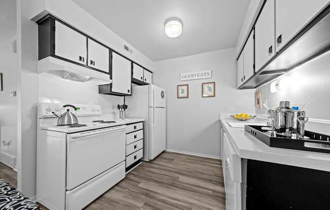 A modern kitchen with black and white cabinets at Westwood Village Apartments in Westland