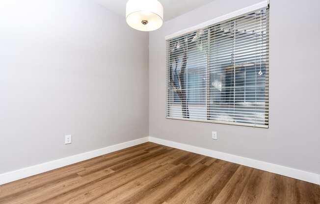 an empty room with wood floors and a window