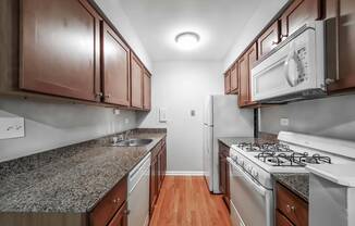 a kitchen with granite countertops and wooden cabinets