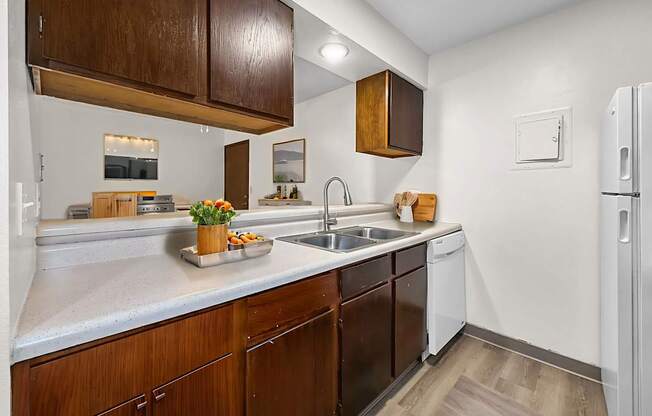 A kitchen with wooden cabinets and a white refrigerator.
