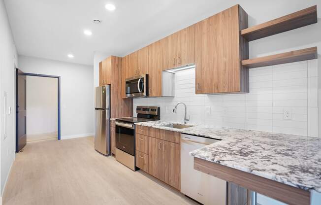 a kitchen with marble counter tops and wooden cabinets