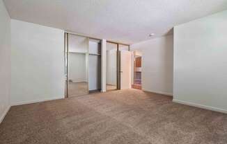 Apartments San Jose CA - Village of Taxco - Bedroom with Beige Carpeting, Mirrored Closet Doors, and White Walls
