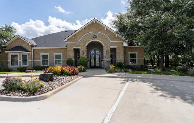 A building with a black gate and a small garden in front.