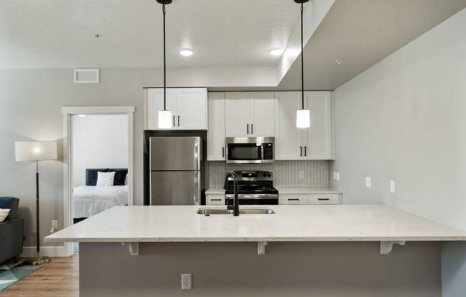 a kitchen with a large island and a stainless steel refrigerator