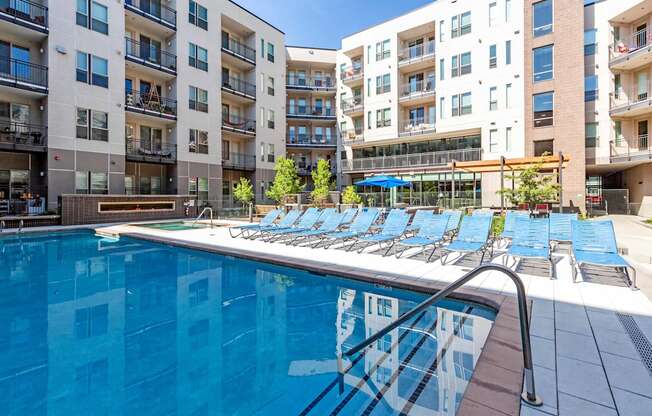 A swimming pool in front of apartment buildings.