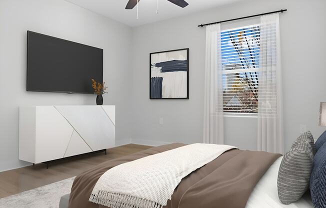 A bedroom with a bed, a television, and a painting on the wall.