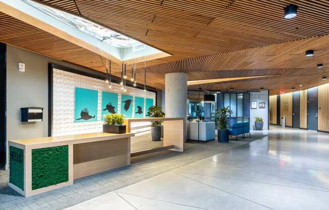 a lobby with a reception desk and green plants