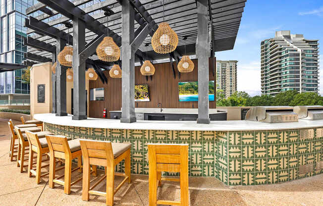 A bar with wooden chairs and a green patterned wall.