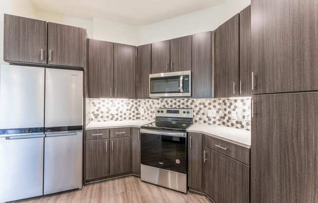 Kitchen with dark wood cabinets and white countertops at Residences at 3000 Bardin Road, Grand Prairie, TX, 75052