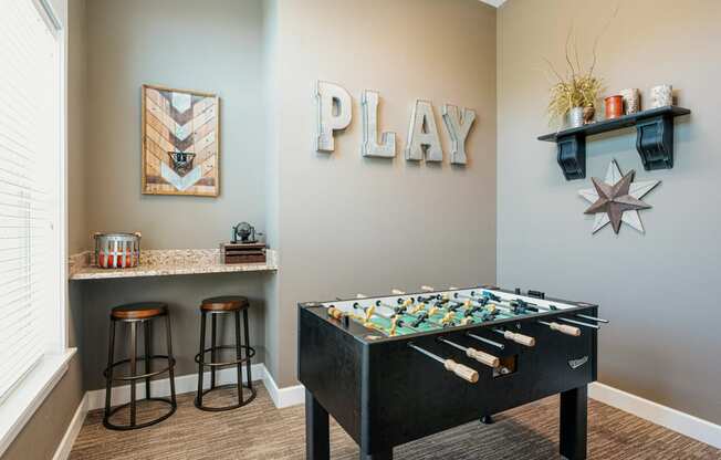 a game room with a foosball table and a play area