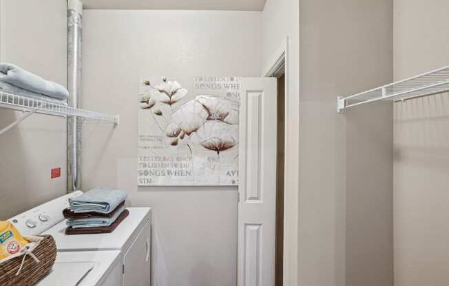 a washer and dryer in a laundry room with a door to the closet