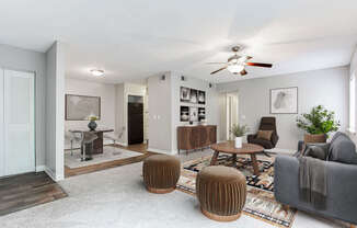 A living room with a grey couch, a wooden coffee table, and a ceiling fan.