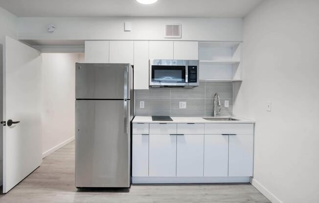 a kitchen with refrigerator and white cabinets at Presidio Palms Apartments, Tucson, AZ