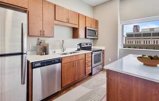 a kitchen with wooden cabinets and stainless steel appliances and a window