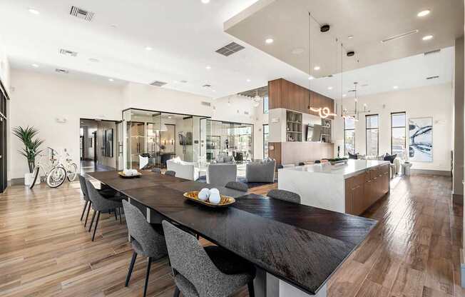 A modern kitchen with a long wooden table and chairs.