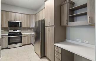 A kitchen with a refrigerator, oven, and microwave.