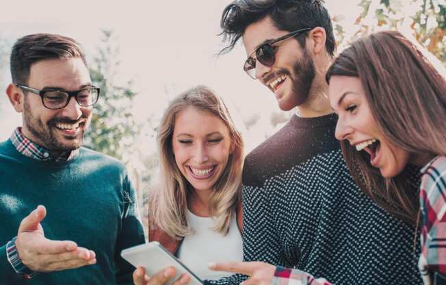 a group of people looking at a cell phone