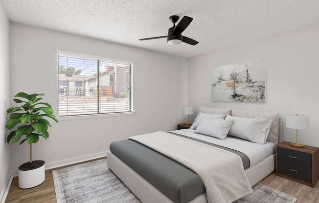 A bedroom with a bed, nightstand, and a plant.