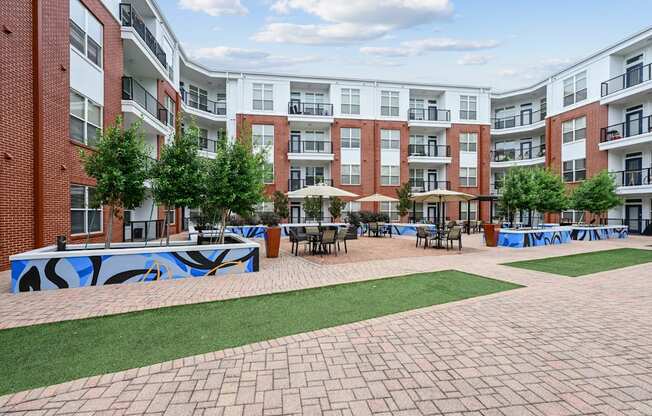 Spacious outdoor courtyard with brick pathways and greenery at The Grand at Upper Kirby apartments in Houston, TX