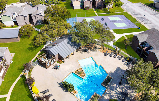 an aerial view of a yard with a swimming pool and houses