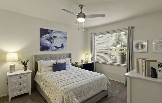 an empty bedroom with a bed and a ceiling fan