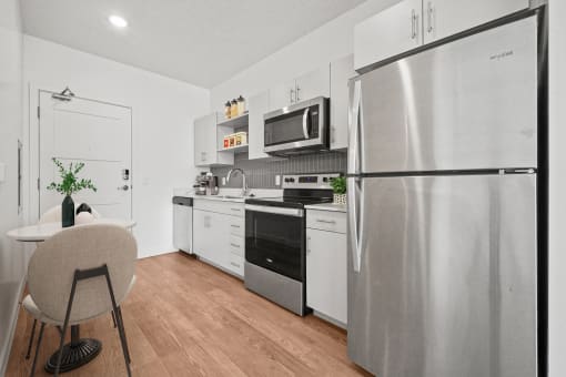 an apartment kitchen with stainless steel appliances and a table and chairs  at SevenO2 Main Apartments, Salt Lake City, UT