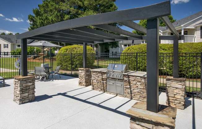a patio with a barbecue grill and a pergola