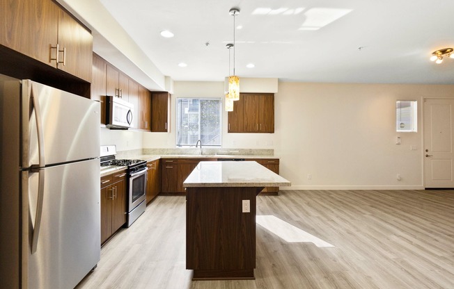 open kitchen with granite countertops and a kitchen island and stainless steel appliances