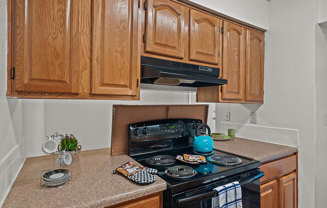 a kitchen with wooden cabinets and a black stove and oven