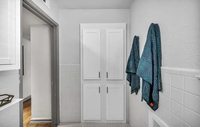 a bathroom with a white door and a blue towel hanging on the wall  at Sunset Ridge, San Antonio, TX