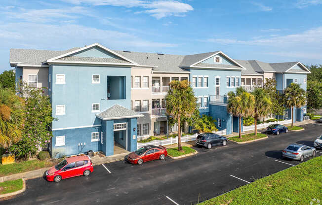 A row of houses with cars parked in front.