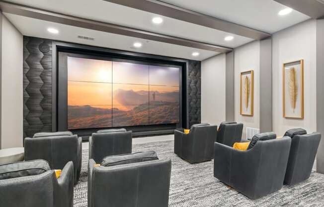 a large screening room with a projector screen and chairs