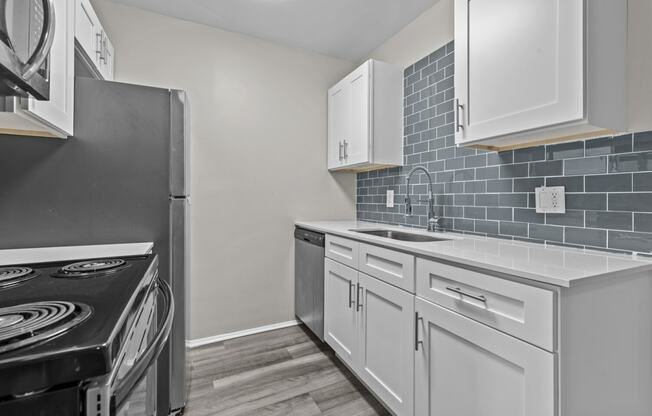 a kitchen with white cabinets and a stove and refrigerator