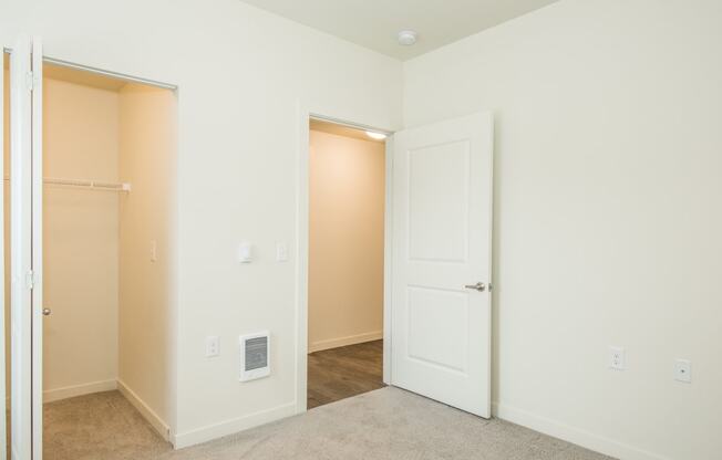 a bedroom with an open door and a closet