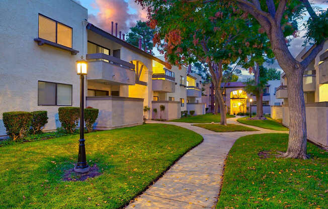 A tree in a grassy area in front of a building.