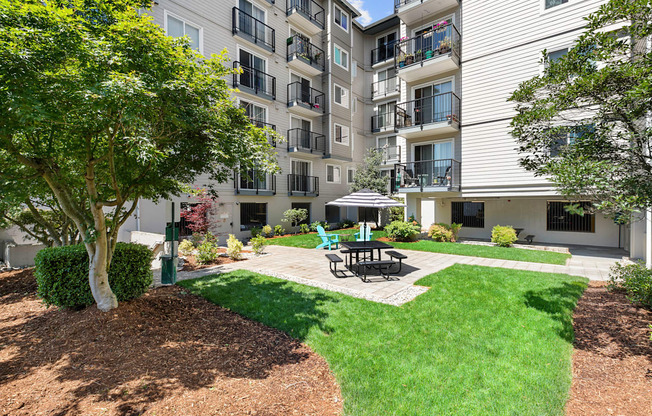 Resident Outdoor Lounge Space with a patio and picnic table with umbrella at King Arthurs Court, Seattle, Washington