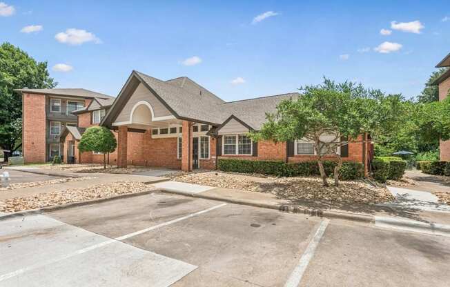 A large brick building with a parking lot in front.