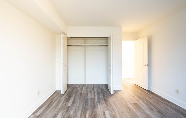 an empty bedroom with white walls and wood floors  at Charlesgate Apartments, Towson, 21204