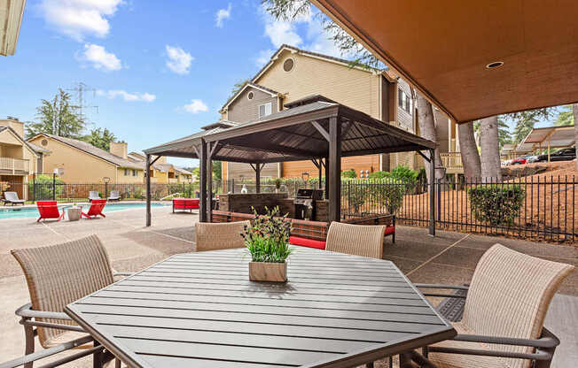 A patio with a table and chairs under a canopy.