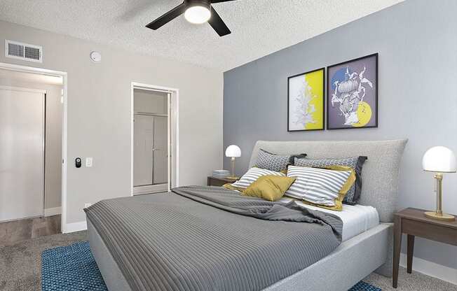 Carpeted bedroom with ceiling fan and private bathroom.