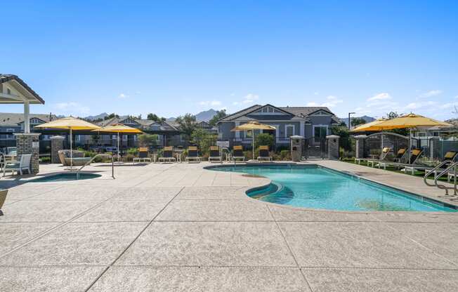 a swimming pool with patio furniture and umbrellas next to a resort style pool