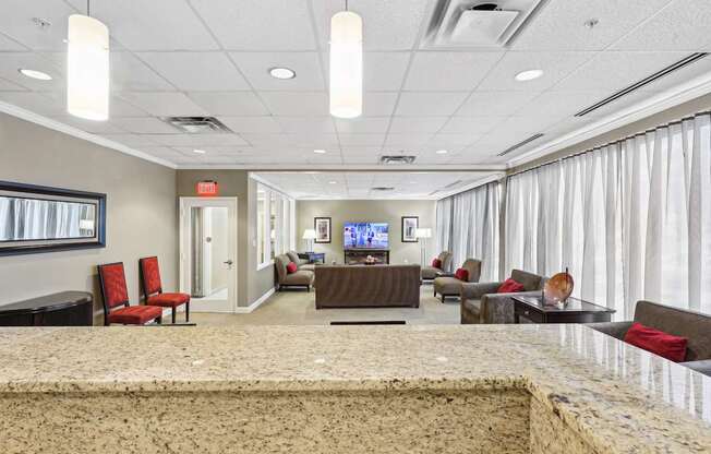 A spacious waiting room with a TV, couches, and chairs.