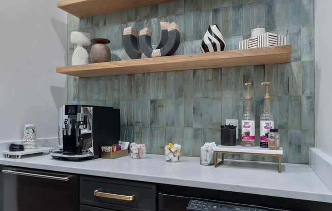 A kitchen with a black oven and a counter with a coffee maker and other items.
